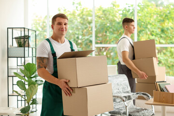 Moving day. Workers holding cardboard boxes with different belongings in office, selective focus