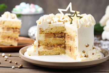 Delicious cake with Christmas decor and marshmallows on wooden table, closeup