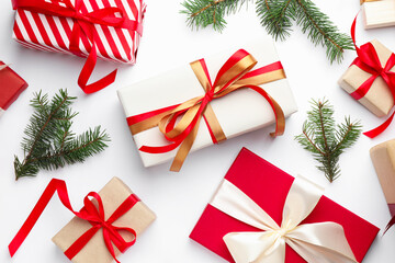 Christmas celebration. Fir tree branches and gift boxes on white background, flat lay