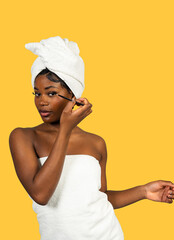 Black woman applying eyeliner for self-care routine