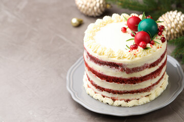 Delicious sponge cake with Christmas decor and red currants on grey textured table, closeup. Space for text