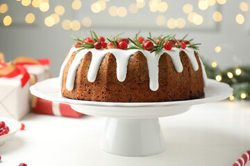 Tasty Christmas cake with icing, cranberries and rosemary on white wooden table, closeup