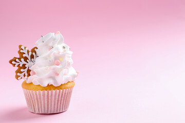 Tasty cupcake with Christmas decor on pale pink background, closeup. Space for text