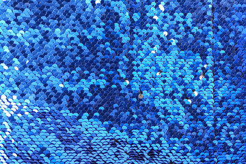Blue shiny sequins with highlights. Background, texture.