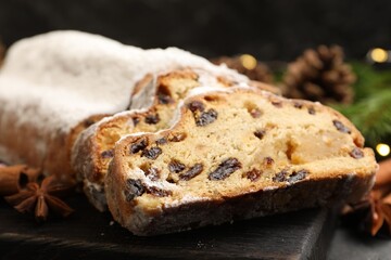 Traditional Christmas Stollen with icing sugar, spices and festive decor on table, closeup