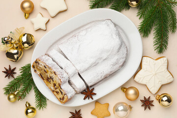 Cut traditional Stollen cake, cookies and Christmas decor on white table, flat lay
