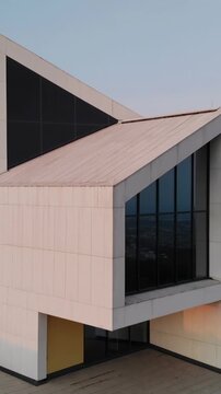 Vertical video: Clip pan starting, camera revealing exterior showing triangular roof and glass wall