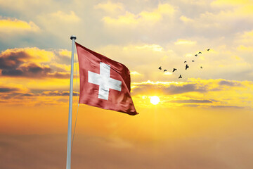 Switzerland flag waving in sunset or sunrise. Switzerland flag for Republic Day and Independence Day.
