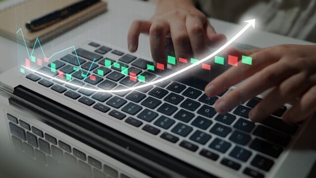 A close-up view of a person typing on a laptop keyboard with a digital graph overlay showcasing financial growth trends, highlighting a modern workspace environment. Copula