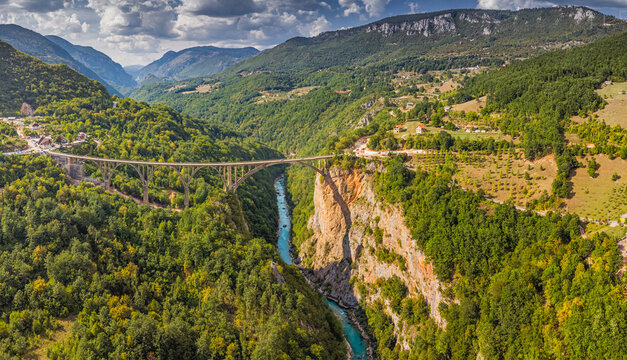 Tara River Canyon and famous Durdevica Bridge surrounded by lush green forests in Montenegro, a stunning aerial view