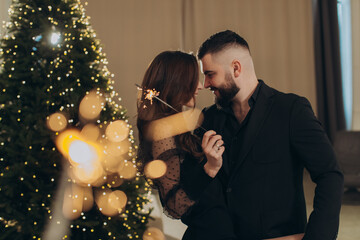 Romantic couple celebrating christmas holidays with sparklers