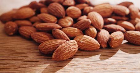 Space, nuts and almonds on table for diet, vegan meal and healthy snack for nutrition. Background, food production and roasted seeds on wooden board for organic benefits, natural vitamins and protein