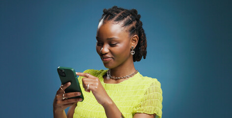 Typing, smartphone and black woman in studio, internet and communication on blue background. Mockup space, mobile user and African person with cellphone, network and message to contact, app and email