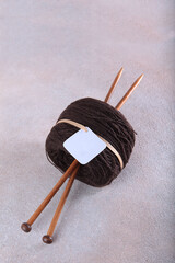 Brown wool yarn for hand knitting. Wooden spokes made of bamboo. Multi-colored wool yarn. Yarn on bobbins. Handmade products. Hobby concept.