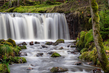 A long exposure view of a waterfall in a small rapid river, autumn landscape, November in nature,...