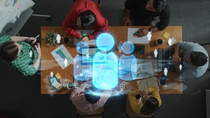 A diverse group of professionals collaborates during a brainstorming session at a modern workspace. A digital hologram enhances the creative environment, symbolizing innovative ideas. Raster