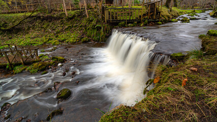 A long exposure view of a waterfall in a small rapid river, autumn landscape, November in nature,...