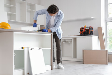 Male worker assembling drawer in kitchen