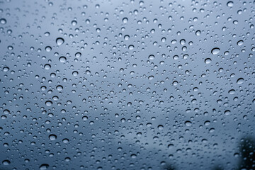 A closeup shot of the glass of a window covered by rain droplets for backgrounds and textures.
