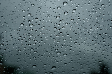 A closeup shot of the glass of a window covered by rain droplets for backgrounds and textures.