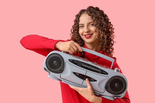Beautiful young woman with boombox on pink background - Powered by Adobe