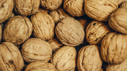 Lots of walnuts in their shells. Top view. Nutritious and delicious food.