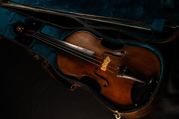 vieux violon posé sur un bel étui ancien de couleur bleu vert.