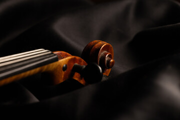 gros plan sur un vieux violon en bois, sur fond noir avec place pour mettre du texte