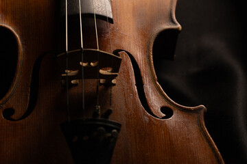 gros plan sur un vieux violon en bois, sur fond noir avec place pour mettre du texte