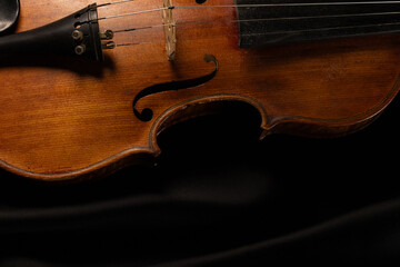 Fototapeta premium gros plan sur un vieux violon en bois, sur fond noir avec place pour mettre du texte