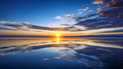 Calm sea and beautiful sunset under cloudy sky.