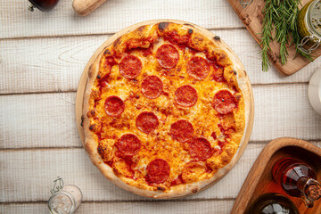 Hot pepperoni pizza with tomato sauce and melted cheese served on a wooden board