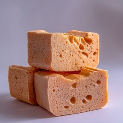 Stacked porous organic sponges sit on a clean surface.