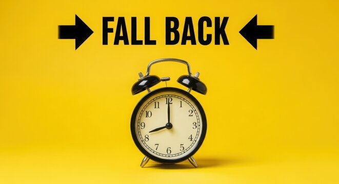 Alarm clock with fall back text on yellow for daylight saving time change concept. - Powered by Adobe