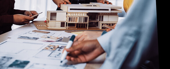 A group of professionals engaged in a creative meeting, discussing architectural design plans and a...