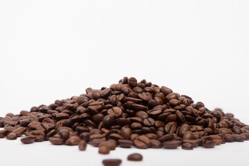 Heap of brown roasted coffee beans isolated on white background