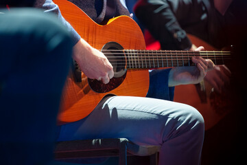 Male musician performing on stage and playing electric guitar during a live concert show with stage lights and sound equipment