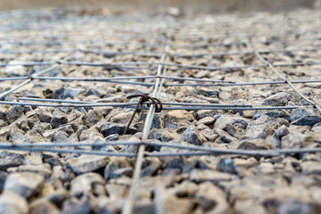 Steel rebar grid tied with wire over crushed stone base for concrete slab reinforcement