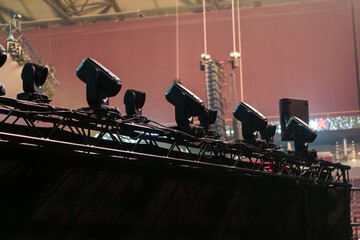Industrial stage lighting mounted on aluminum frames inside the venue, prepared to illuminate the live performance area