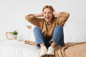 Obraz premium Screaming mature woman sitting in bedroom