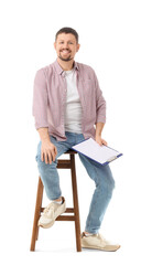 Male actor with film script sitting on white background