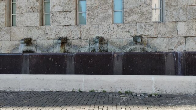 Rome, Italy - July 15, 2025, detail of fountains consisting of four bronze nozzles that poured water into a rectangular basin.