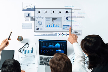 Team collaborates on data analysis using a laptop and various visualizations, showcasing the importance of teamwork and technology in modern business strategies. Trope