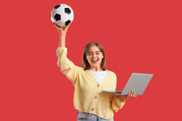 Happy young woman with soccer ball and laptop on red background. Sports bet concept © Pixel-Shot