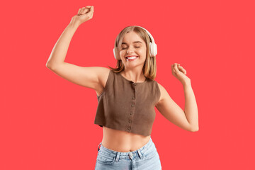 Young woman in headphones listening to music on red background