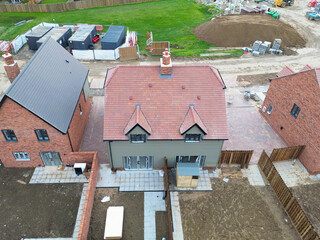 Interesting drone view of a near completed semi detached first time buyer property within a British housing development site. Note the finished garden shed on the back patio, soon to be moved.