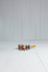 Obraz premium Wooden Baby Rattle and Block on a White Wooden Floor
