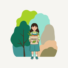 Smiling girl holding organic bag with eco concept text in forest