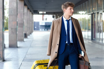 Young businessman with baggage near airport