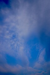 High contrast blue sky with tall cirrus clouds creating dramatic vertical patterns